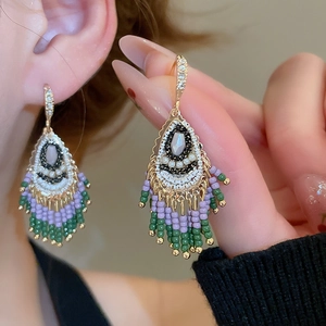 Close-up of Bohemian crystal tassel earrings worn by a model in a lifestyle shot