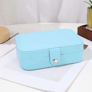 Sky blue jewelry box with snap fastener on a clean minimalist tabletop with plants