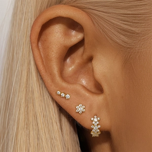 Close-up of three gold S925 sterling silver earrings with square zirconia on ear