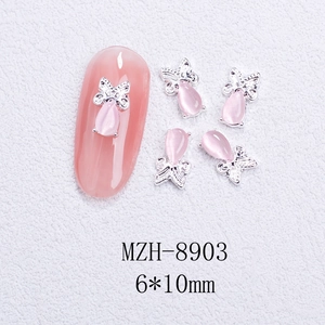 Detailed macro of 6x10mm pink cat eye stone nail charm with silver butterfly frame