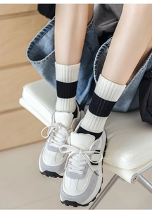 Detailed view of striped cotton socks styled with casual sneakers and denim shorts
