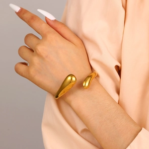 Polished gold water drop open bangle bracelet shown on model with minimalist style