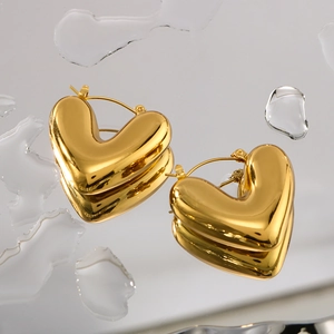 Elegant 18K gold plated hollow heart hoop earrings on reflective water surface