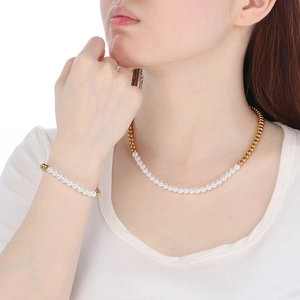 Primo piano della collana in perle d'acqua dolce e sfere d'acciaio placcato oro 18K