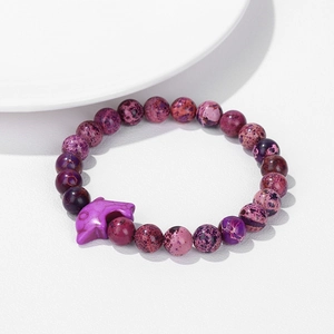 Close-up of purple stone beaded bracelet with a charming dolphin pendant on white background