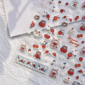 Detail of 3D embossed nail stickers featuring cute bears, strawberries, and flowers