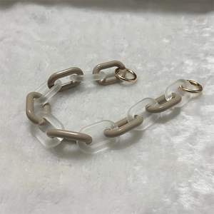 Detail of chunky acrylic chain link strap with khaki resin links and golden clasps