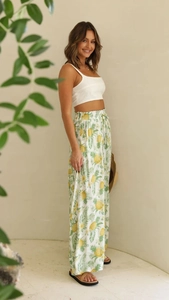 Detail of white wide-leg trousers with pineapple print and elastic waistband for summer