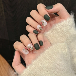 Détails macro d'ongles faits main avec un motif de sapin d'hiver vert foncé