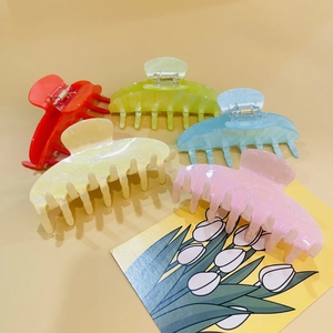 Flat lay of colorful acrylic shark hair claws in red, blue, and glitter finishes