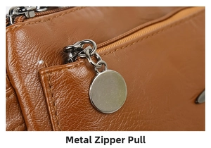 Detail of gunmetal zipper puller on brown lychee texture leather shoulder bag