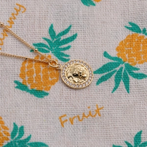 Collier à pendentif relief tête de lion dorée avec halo de zircons et chaîne perlée