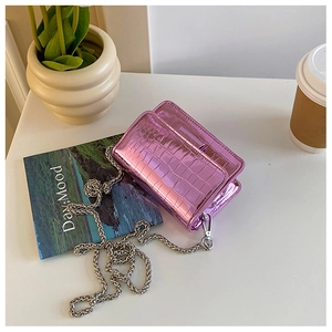 Detail of pink-purple crocodile pattern texture and thick silver chain on mini bag