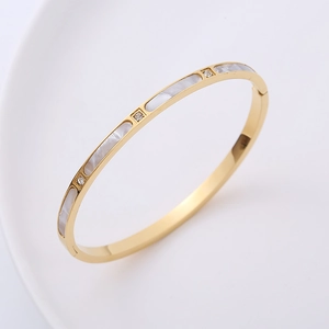 Gold-plated cuff bracelet featuring white shell segments and micro-pave cubic zirconia