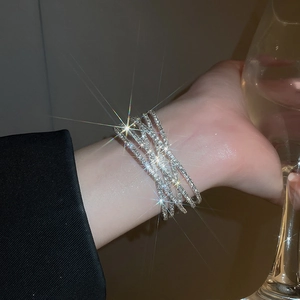 Detail of a sparkling multi-layer silver rhinestone wrap bracelet on a model wrist