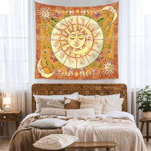 Detail of sun and moon tapestry with zodiac symbols hanging above a cozy bed