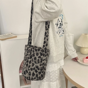 Detail shot of leopard print faux fur bucket bag on model in cozy indoor setting