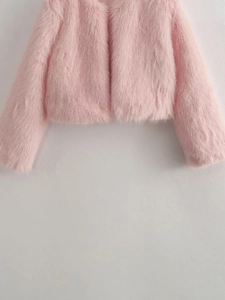 Gros plan détaillé sur la texture en fausse fourrure rose de cette veste courte