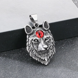 Detailed close-up of a vintage Fenrir wolf pendant with red gemstone and silver texture