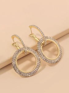 Close-up of interlocking gold-tone geometric hoop earrings with sparkling crystal pavé