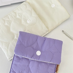 Detail of heart quilted sanitary storage bags in purple and off-white with button closure
