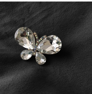 Macro shot of sparkling crystal butterfly brooch on dark velvet textured background