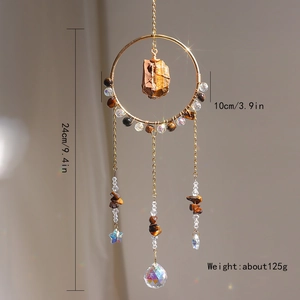 Detail of sun catcher with tiger eye stone and crystal ball in a gold metal ring