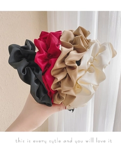 Gros plan de quatre chouchous en satin de qualité supérieure en noir, bordeaux et beige