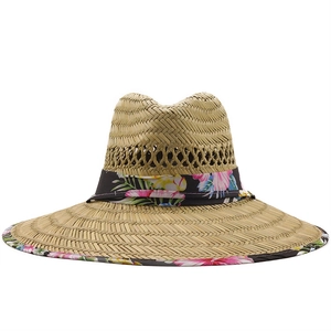 Dettaglio della trama in paglia naturale e del bordo floreale su un cappello a tesa larga