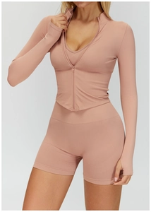 Détail de la texture côtelée et des passe-pouces sur le haut de yoga rose poudré