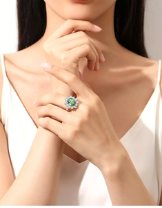 Close-up of S925 silver ring featuring a large oval green emerald and micro-pave diamonds