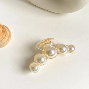 Detail of elegant pearl hair claw clip with transparent base and five gradient pearls