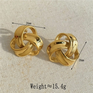 Golden geometric twisted irregular hoop earrings with textured metal finish and 26mm diameter