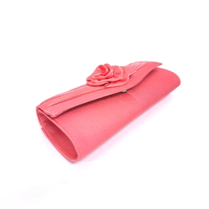 Close-up of pink satin evening clutch featuring 3D handmade rose and pleated texture