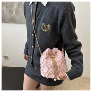 Detail of pink denim bucket bag with raw edge quilting and elegant pearl drawstring charms
