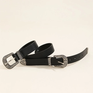 Detail of vintage silver engraved double buckles on black leather western style belt