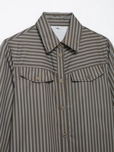 Detail of coffee striped poplin shirt showing fabric texture, pocket and buttons