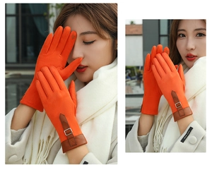 Detail of orange suede gloves with brown leather buckle and touchscreen fingertips