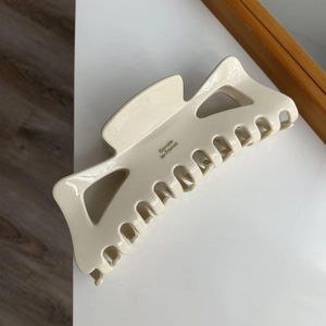 Détail d'une grande pince à cheveux crème avec l'inscription dorée Barrette La France