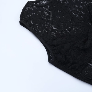 Close-up of intricate black lace patterns and hemline stitching on a sheer dress