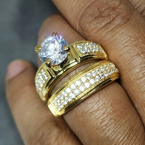 Gros plan d'un ensemble de bagues dorées avec diamant solitaire et anneau pavé brillant
