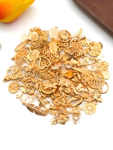 Close-up of assorted gold alloy charms including tree of life and sun shapes for DIY jewelry