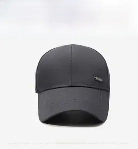 Détail d'une casquette gris foncé avec logo métallique et coutures renforcées sur la visière