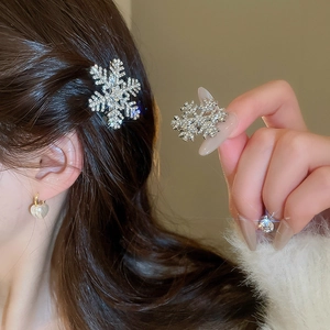 Detailed view of silver snowflake hair clip with shiny rhinestones on brown hair