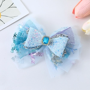 Detail of blue snowflake bow hair clip with central gemstone and glitter mesh layers