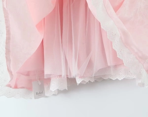 Détail du tulle rose à plusieurs épaisseurs et de la broderie en dentelle blanche