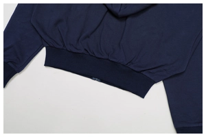 Detailed close-up of ribbed hem and zipper on navy blue athletic zip-up hoodie