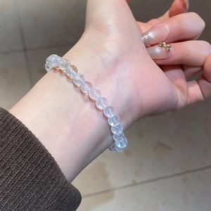 Close-up of clear crystal beaded bracelet with soft moonlight luster on female wrist