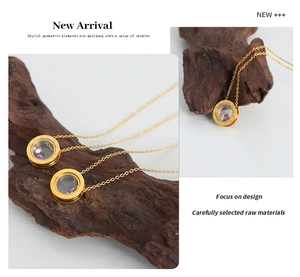 Detail of gold circular pendant necklace with colored stones and Roman numerals