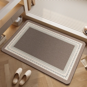 Absorbent brown diatomaceous earth bath mat with cream woven border on wood floor